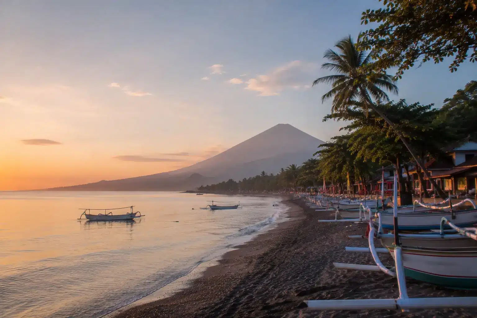 Traditional fishing boats along the coastline of Amed Bali with Mount Agung in the background